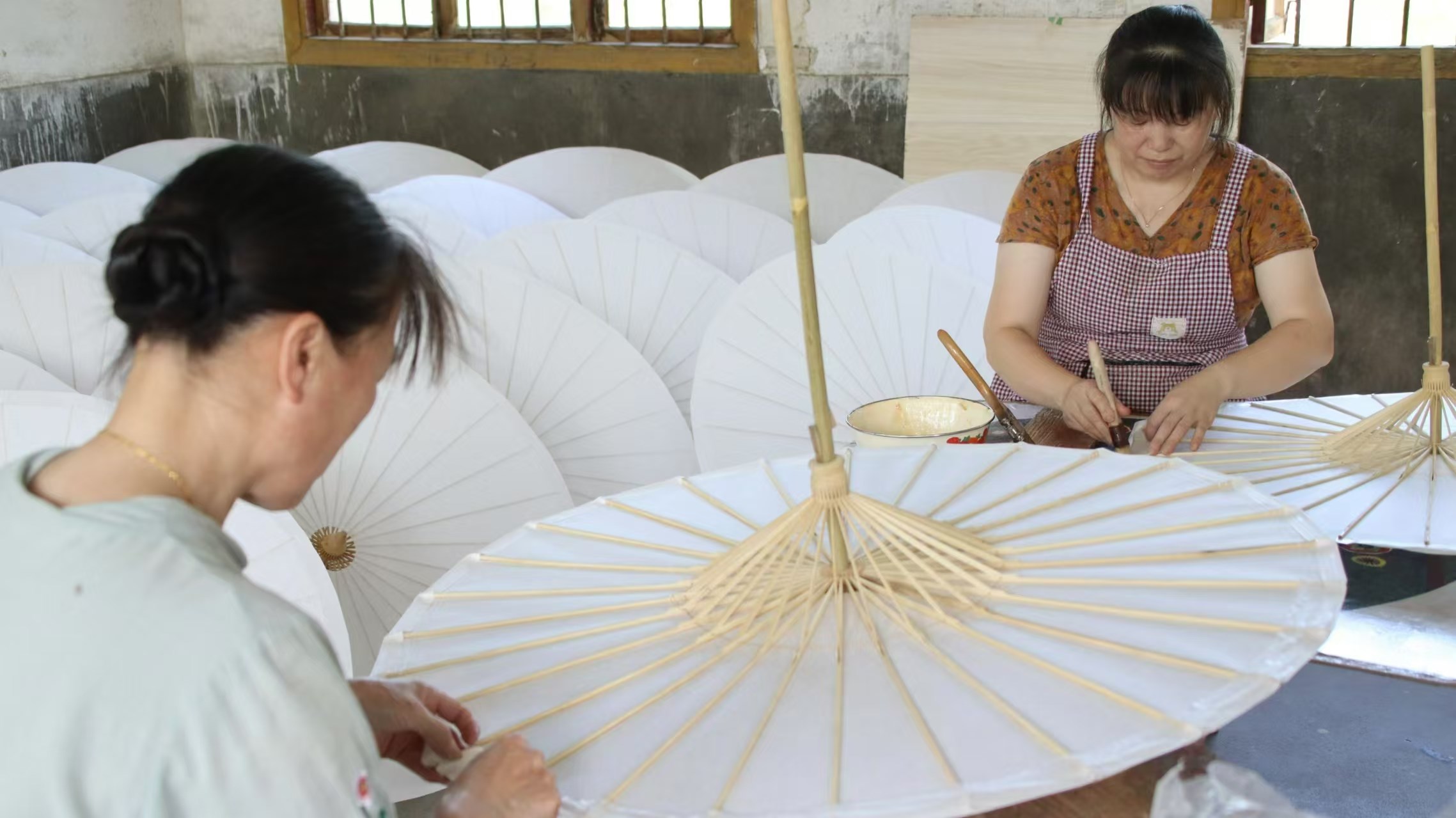 甲路傘廠(chǎng)工人對(duì)傘面進(jìn)行加砂合裱
