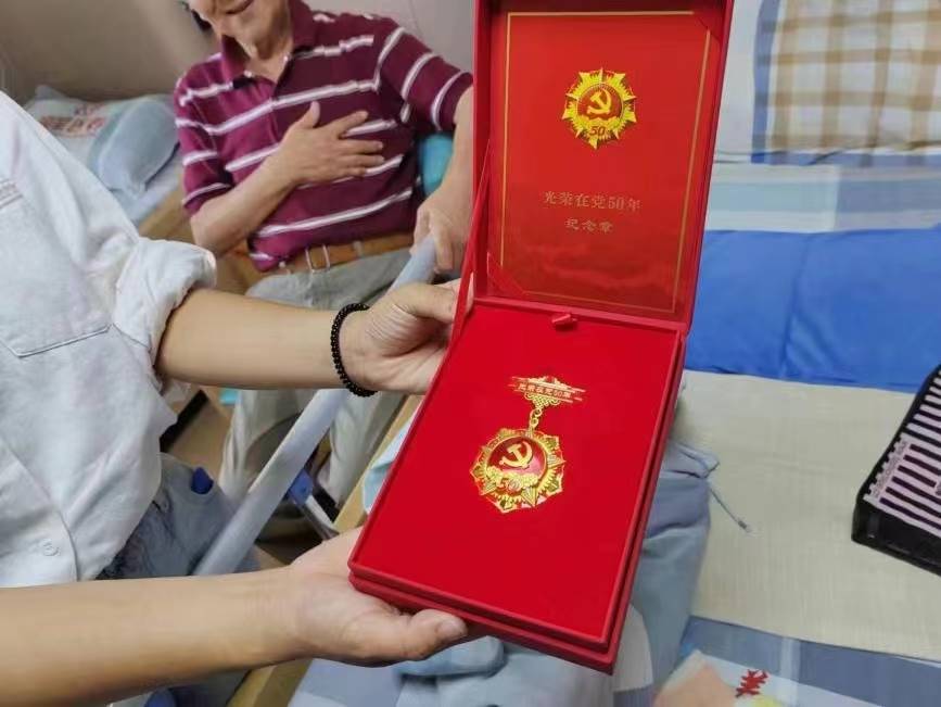 圖為喬亞光老人被授予的入黨50周年紀(jì)念章