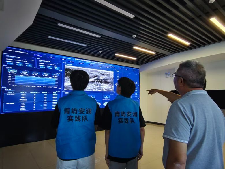 圖為工作人員給成員們講解智能檢測系統